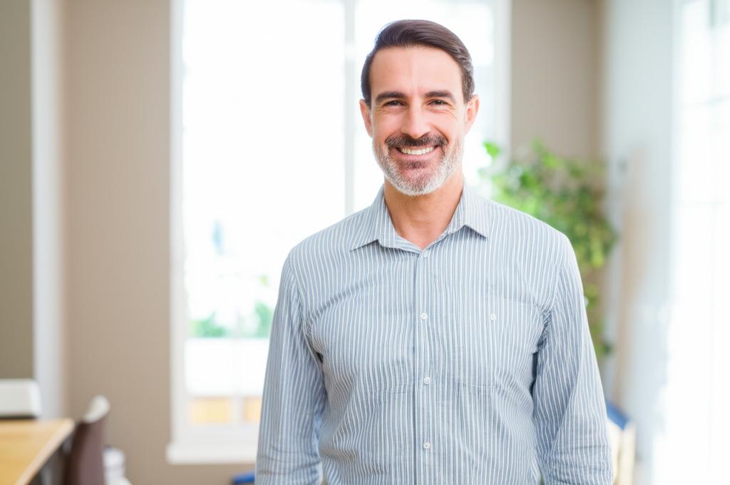 A middle-aged man smiling confidently, perhaps with his arm around his partner, symbolizing restored confidence and relationship happiness.