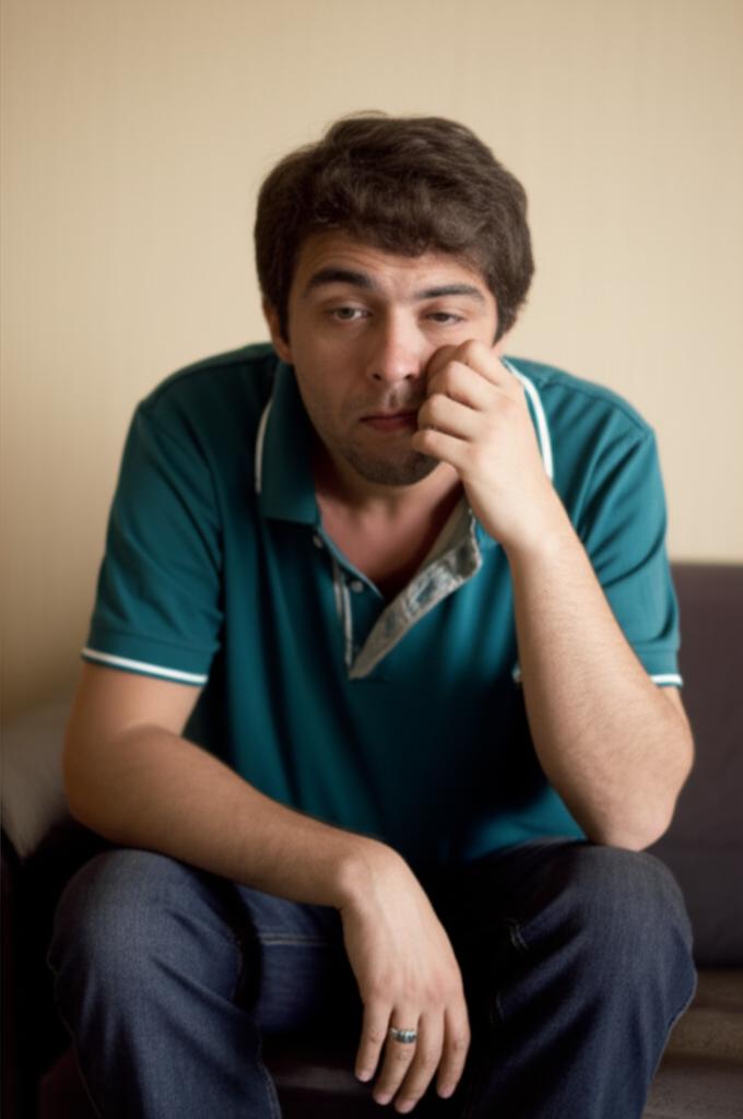 Man sitting alone feeling tired after temporary boost, looking reflective
